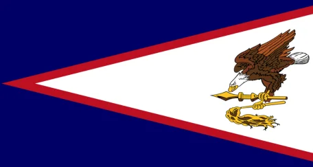 Flag of American Samoa: A blue field with a white triangle on the left, featuring a red outline and an eagle holding a war club in the centre.