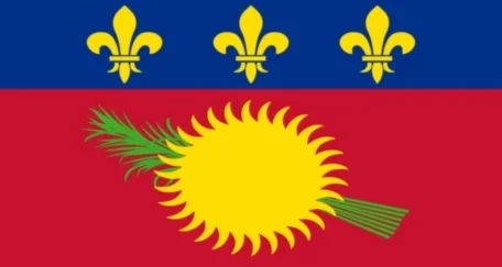 The flag of Guadeloupe often shows a black field with a yellow sun and green sugarcane, and a blue stripe with three yellow fleurs-de-lis at the top.