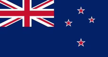 The New Zealand flag features a dark blue field with the Union Jack in the canton and four red stars with white borders on the right side, representing the Southern Cross constellation.